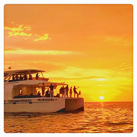 Party Boat Kota Kinabalu with people on a sunset cruise over water