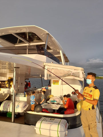 Person on a Party Boat Kota Kinabalu with fishing equipment and supplies.