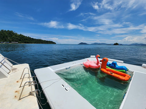 Mini pool with colorful floaties on the Snowy Yacht, surrounded by calm blue sea and scenic islands near Kota Kinabalu.