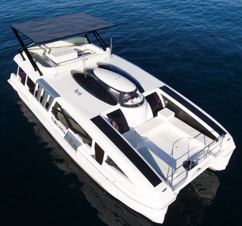 Aerial view of the Snowy Yacht cruising on calm blue waters near Kota Kinabalu, showcasing its modern design and spacious upper deck.
